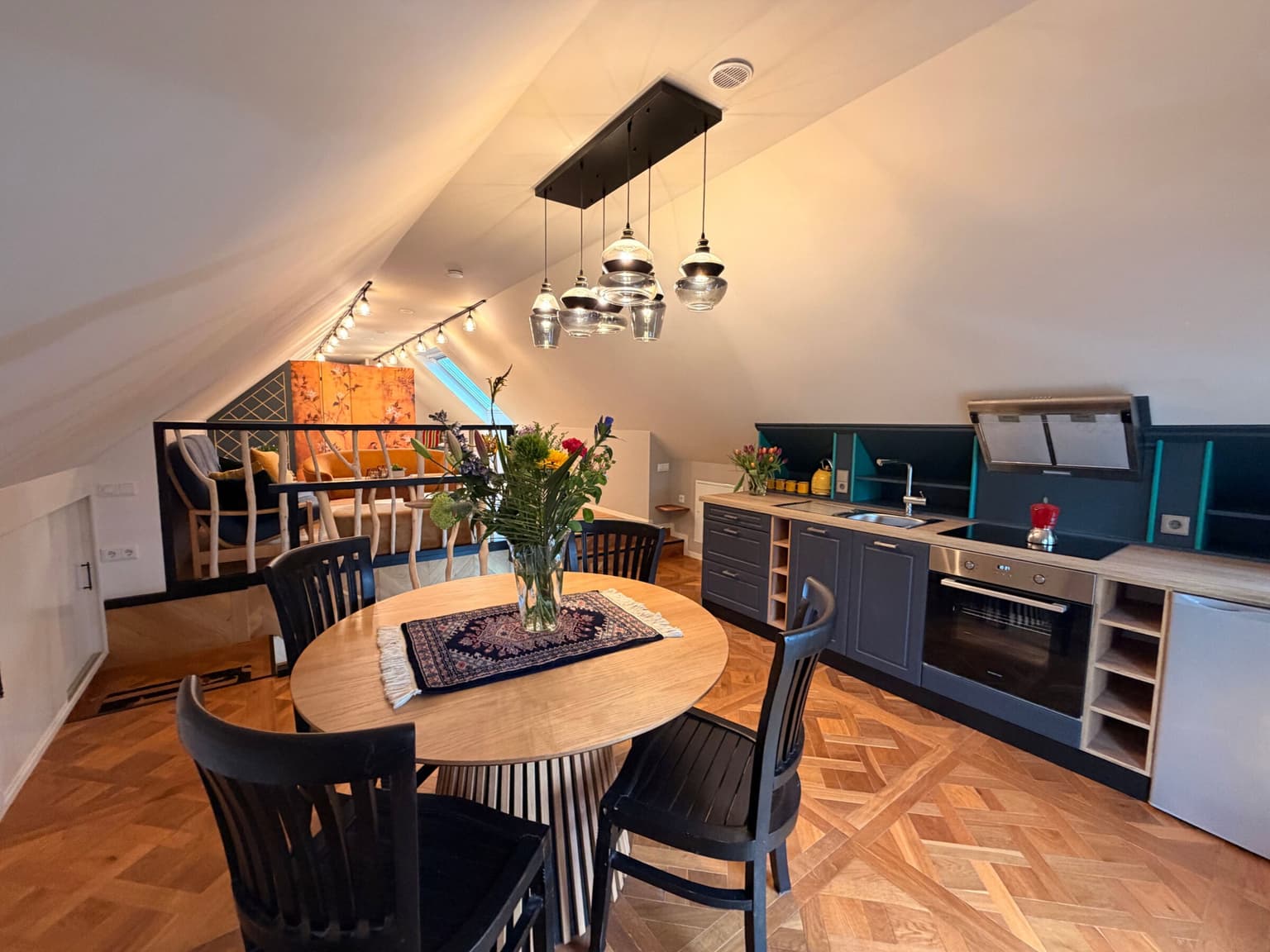 Eettafel en open keuken onder het schuine dak van de Horizon loft